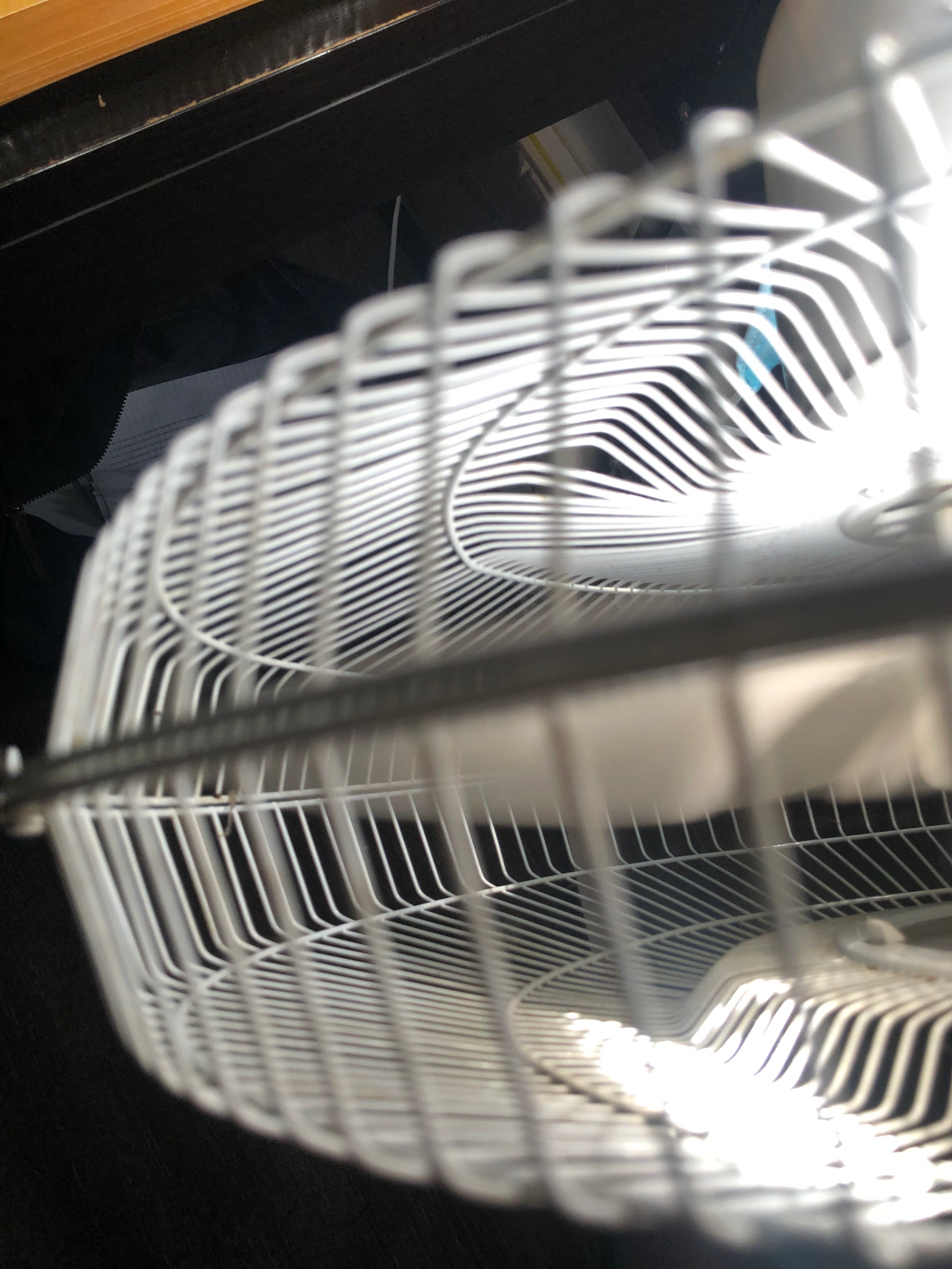 top-down close-up photo of a white fan, a black bag in the far background with notebook paper in it. taken at the robledo art, strike! headquarters, february 2023.